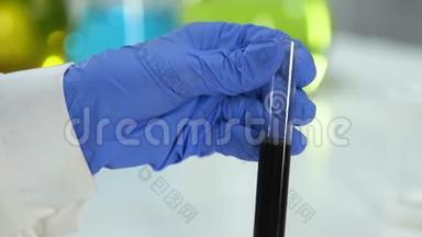 研究实验室助理检查原料油中杂质和沉积物的样品